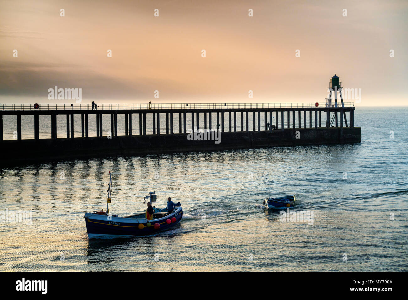 La voile dans le port de pêcheurs de Whitby dans la soirée après la collecte dans leurs filets à Sandsend sur le littoral du Yorkshire du Nord. Banque D'Images