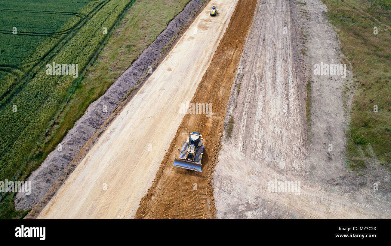 Photo aérienne d'une chargeuse-pelleteuse et un rouleau compresseur sur route, travail, France Banque D'Images