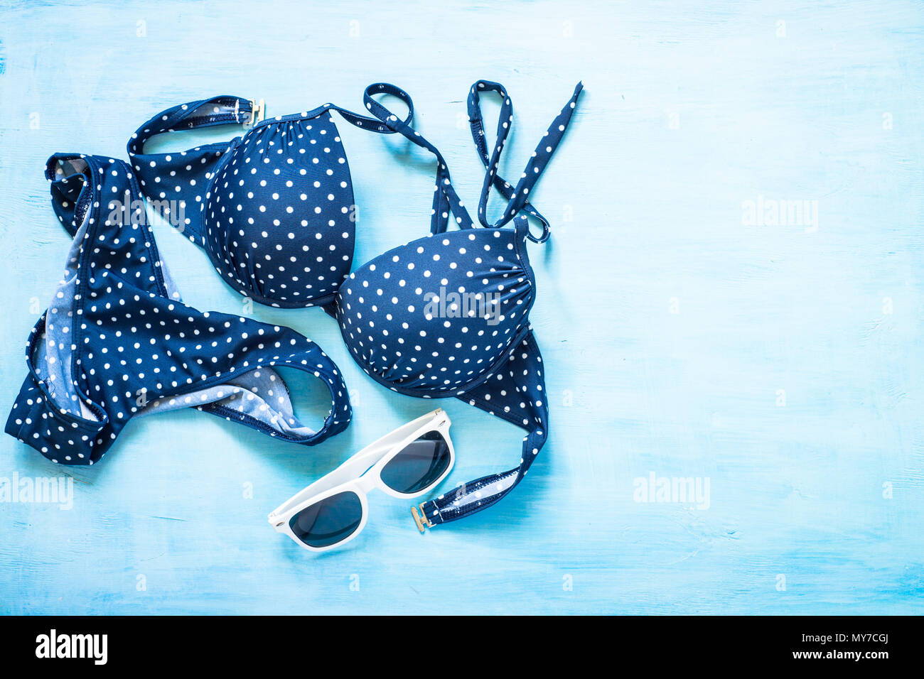 Maillot de bain et lunettes de soleil sur fond bleu clair. Banque D'Images