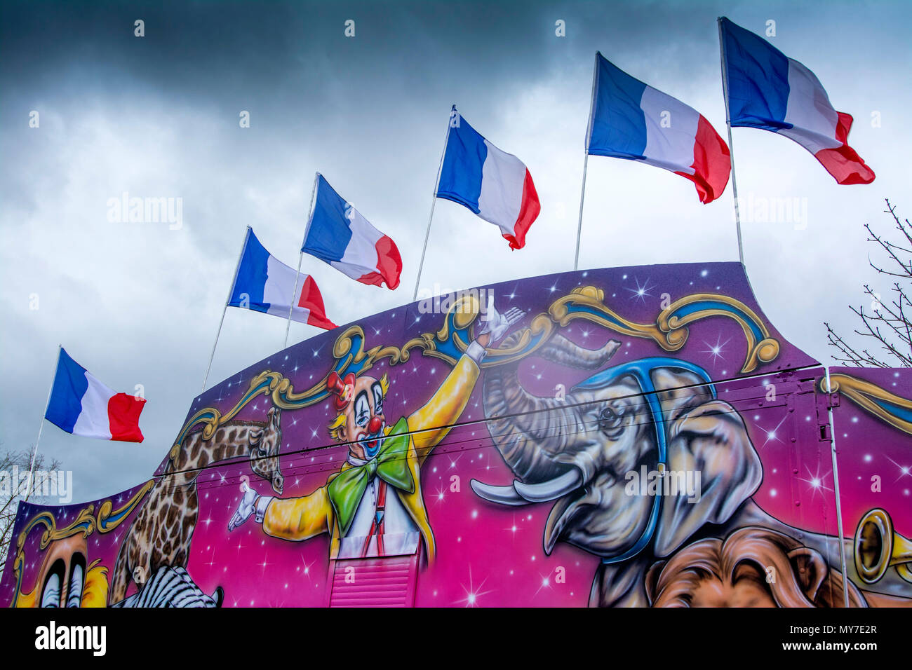 Murale colorée de cirque avec drapeaux français et illustrations animales vibrantes pendant une journée couverte Banque D'Images