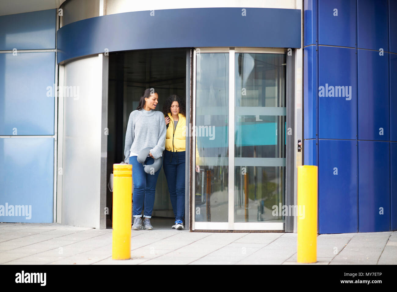 Les femmes de sortir de la porte tournante airport terminal Banque D'Images