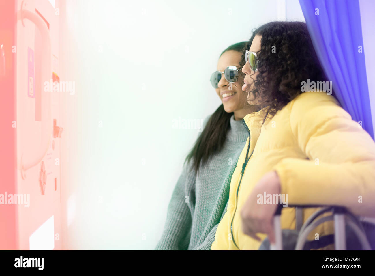 Deux femmes adultes par distributeur automatique in airport Banque D'Images