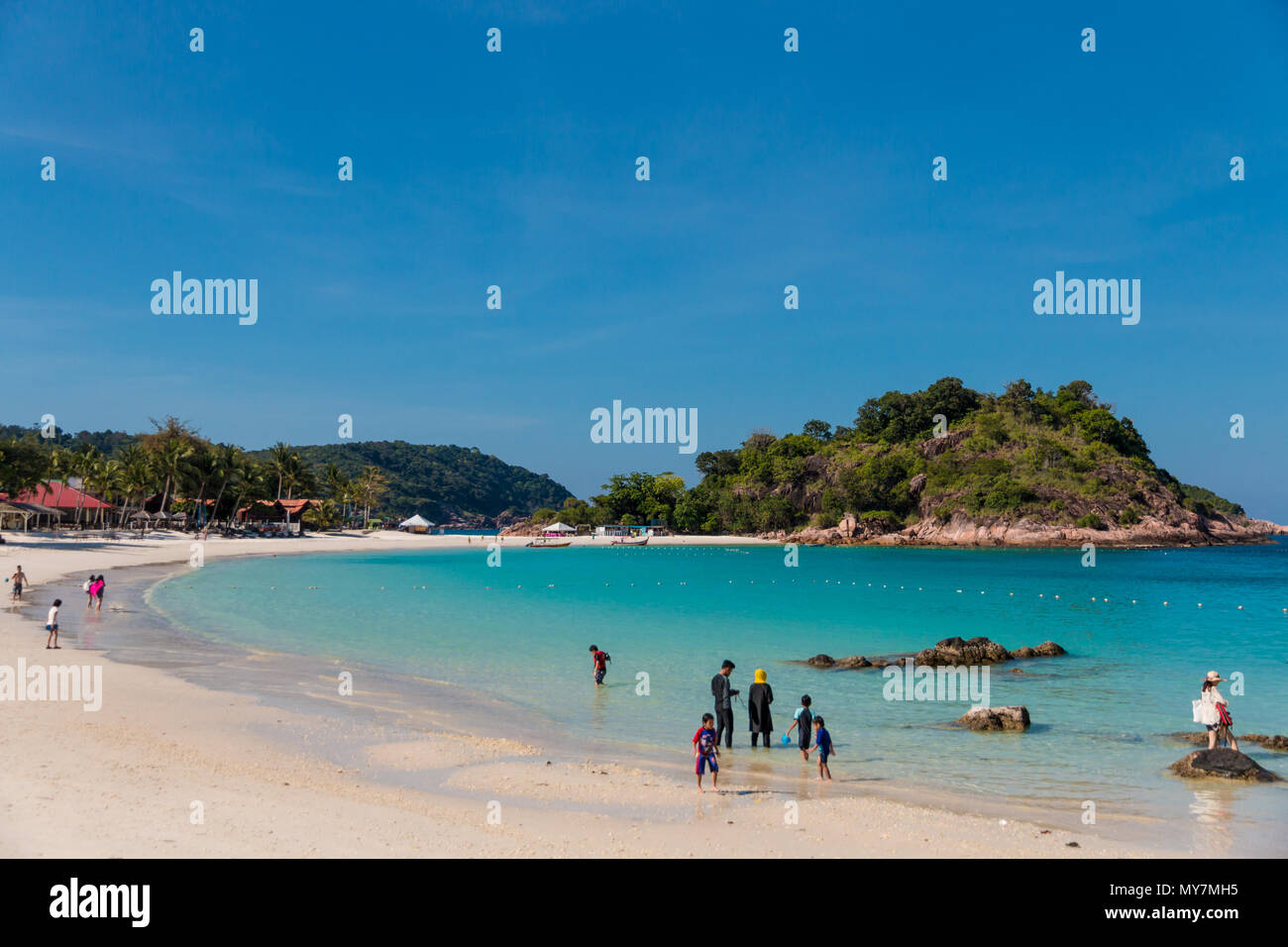 Les touristes, les adultes et les enfants profitent de leur temps libre à la longue plage de sable blanc (Pasir Panjang) avec son eau cristalline de l'eau. Banque D'Images