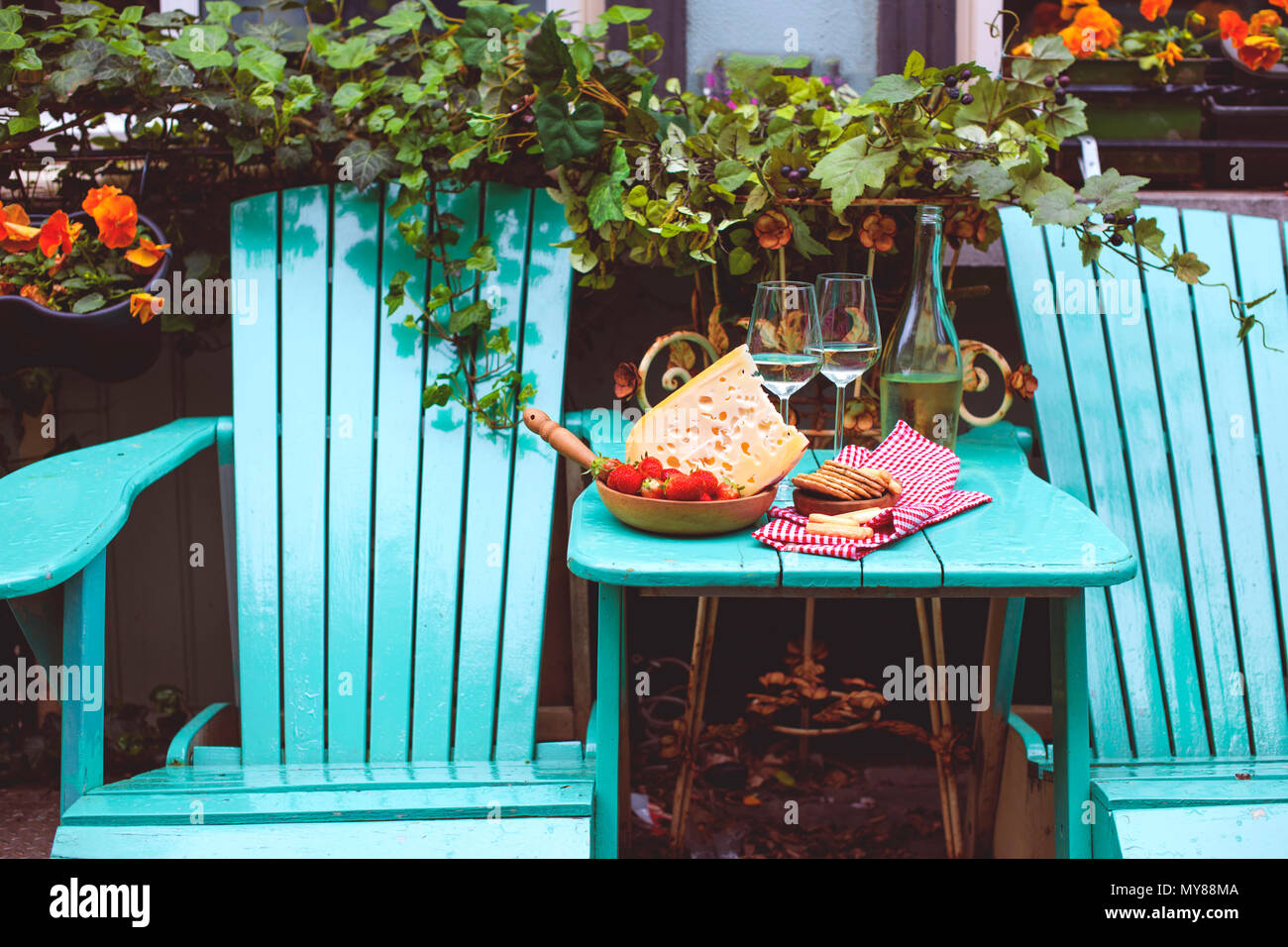Fromage avec des trous et de fraises. Vin blanc dans un verre et des collations. La nourriture sur le balcon , copy space Banque D'Images