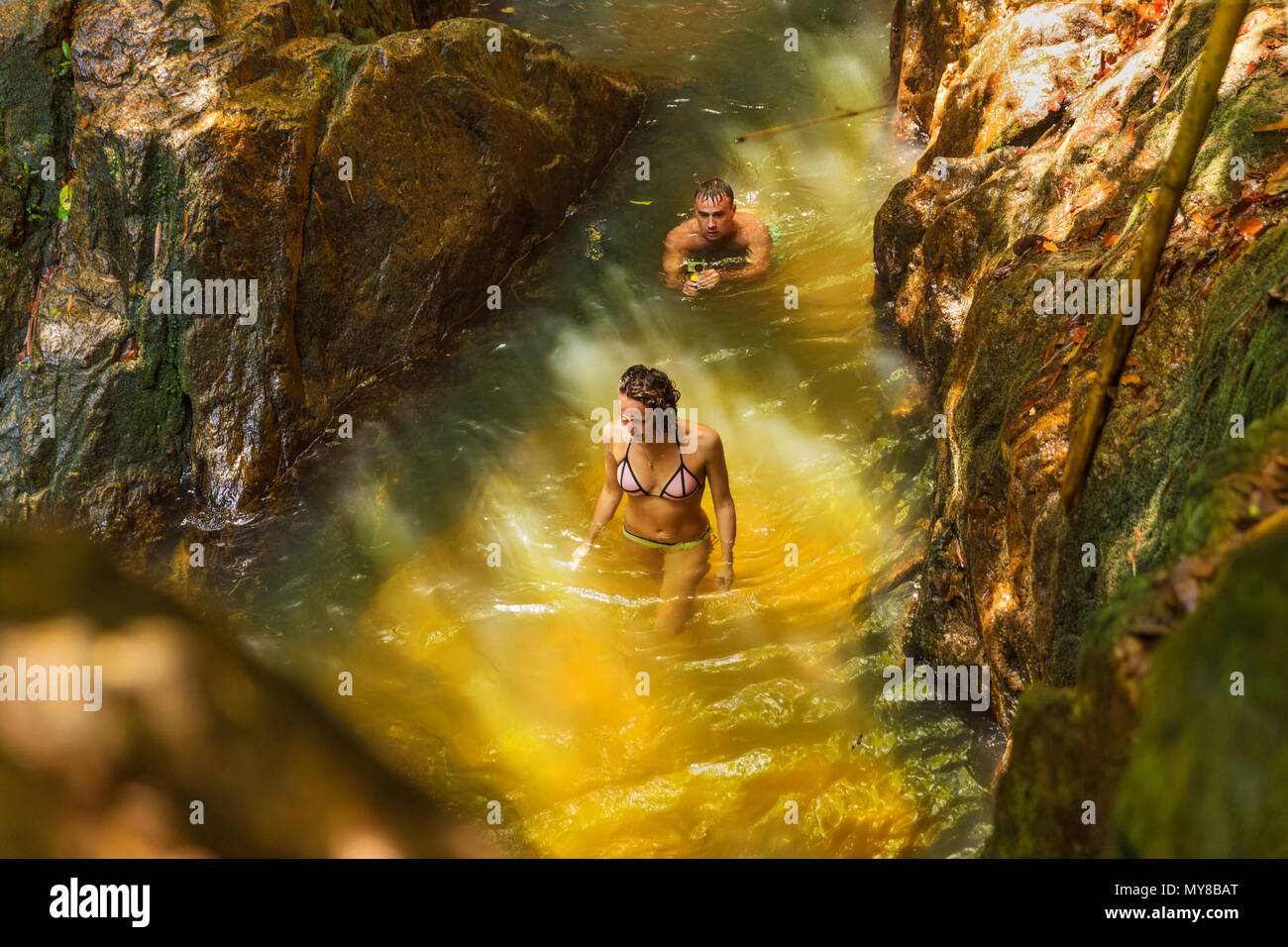 Action de l'homme avec l'appareil photo enregistre son amie la natation dans un wate Banque D'Images
