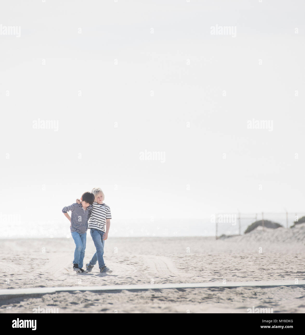 Les garçons marchant sur une plage de sable Banque D'Images