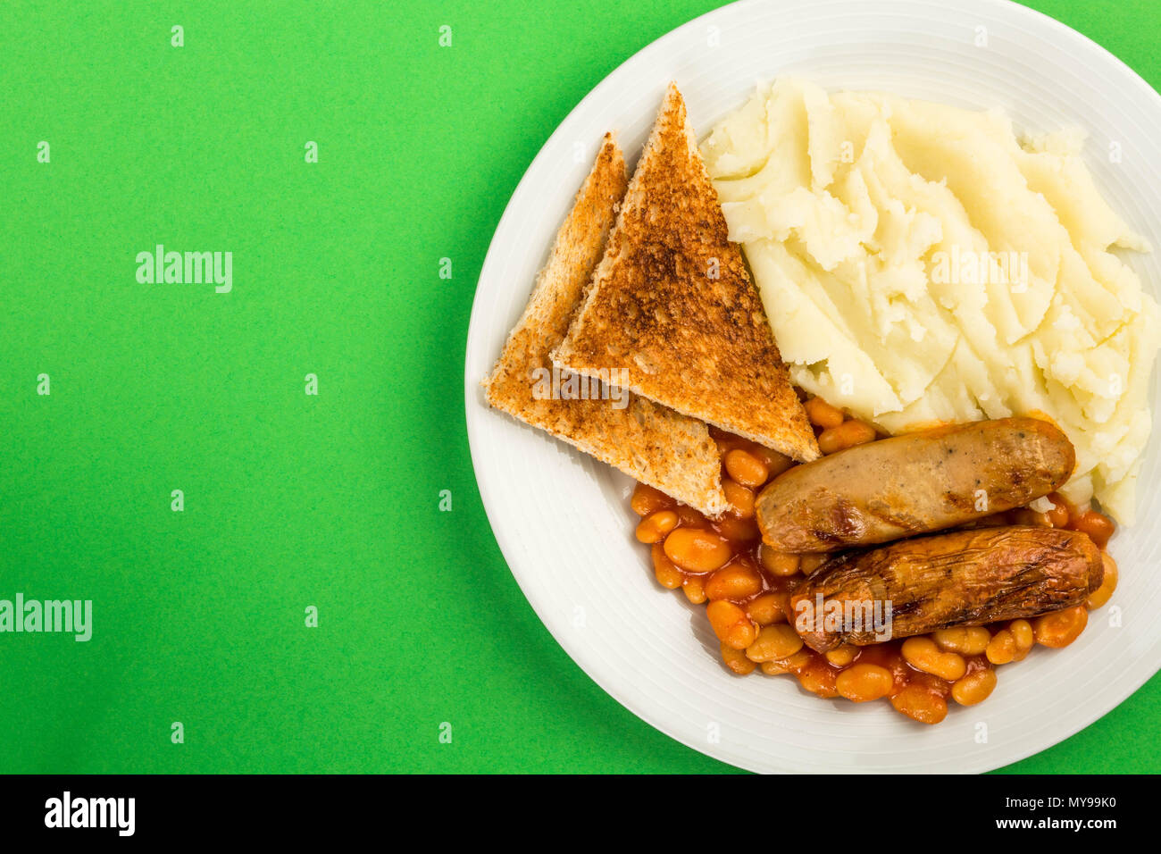 Saucisses de porc avec des haricots blancs et purée de pommes de terre et de pain grillé Banque D'Images