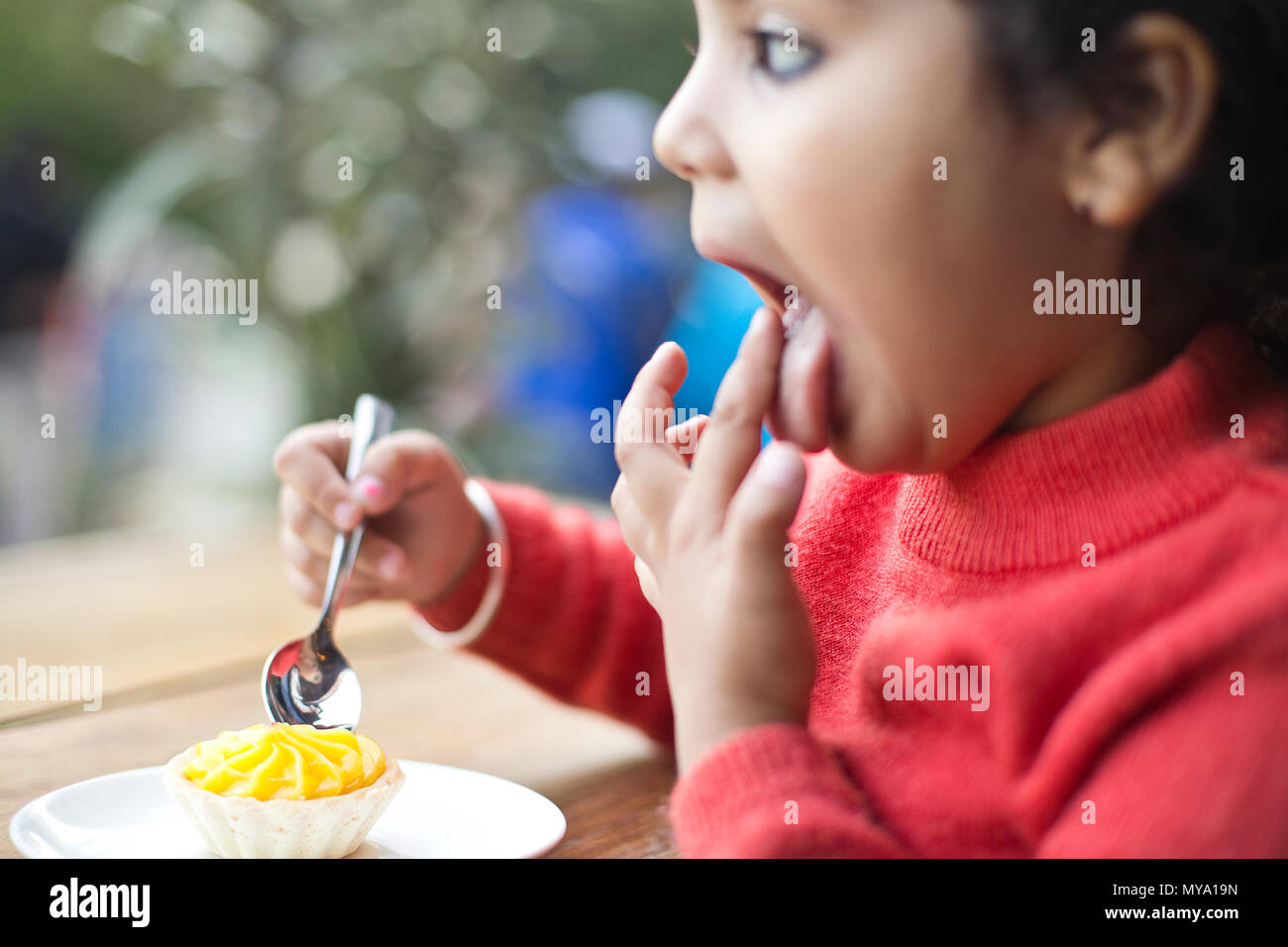 Little girl eating tranche de gâteau au restaurant Banque D'Images