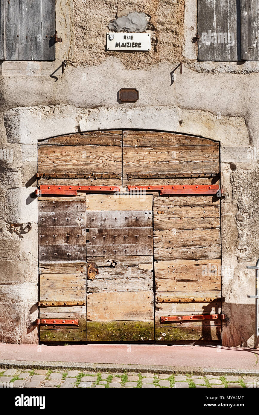 Un ancien garage porte faite de plusieurs morceaux de bois a subi des siècles d'intempéries sur Rue Maziere dans la ville de Beaune en Bourgogne, en France. Banque D'Images