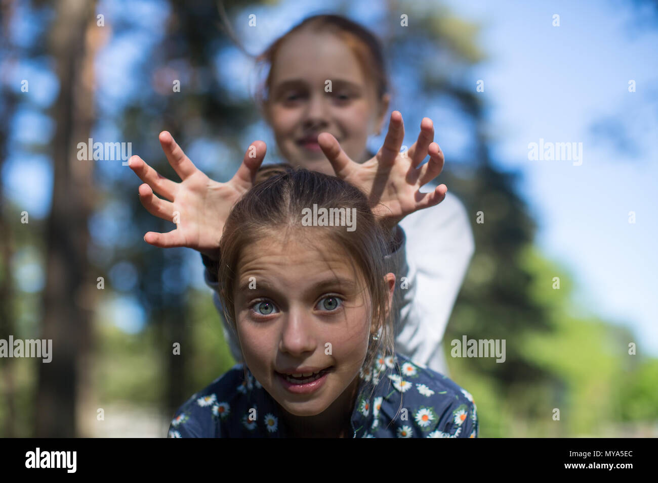 Deux filles soeurs ou des amis s'amuser dans le parc. Recherche dans l'appareil. Banque D'Images