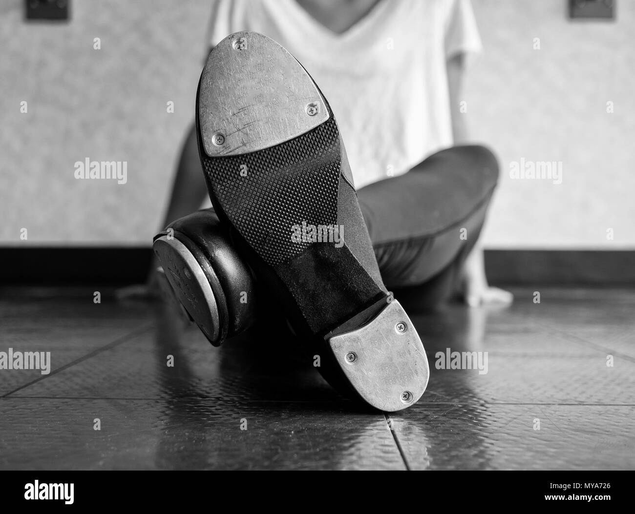 Version noir et blanc de jambes croisées danseur de claquettes et ses chaussures Banque D'Images