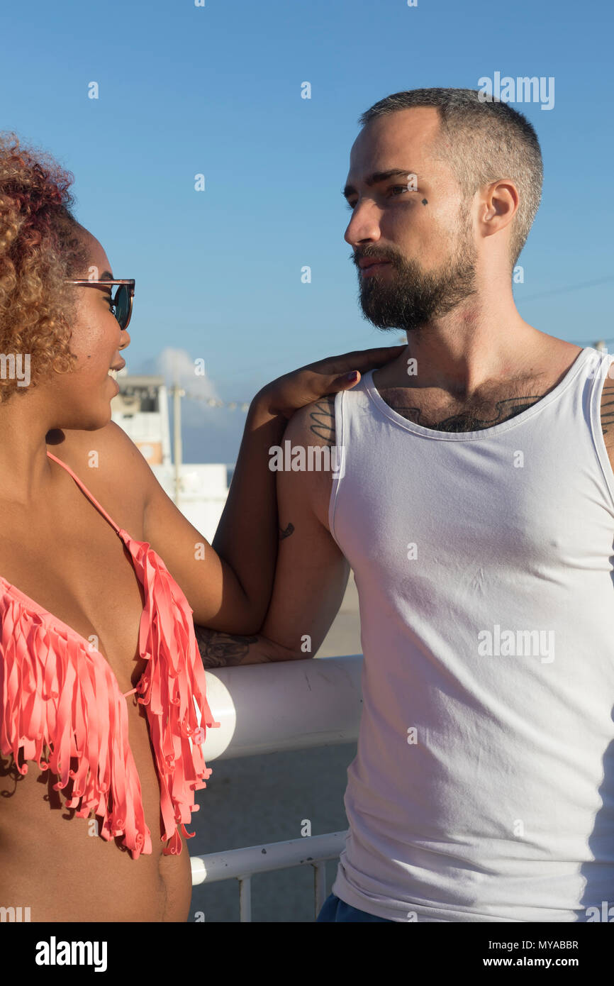 Couple mixte a couru sur la plage ensoleillée en été locations Banque D'Images