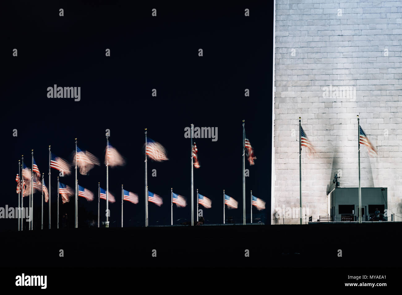 Des drapeaux américains et Washington monument la nuit, à Washington, DC. Banque D'Images