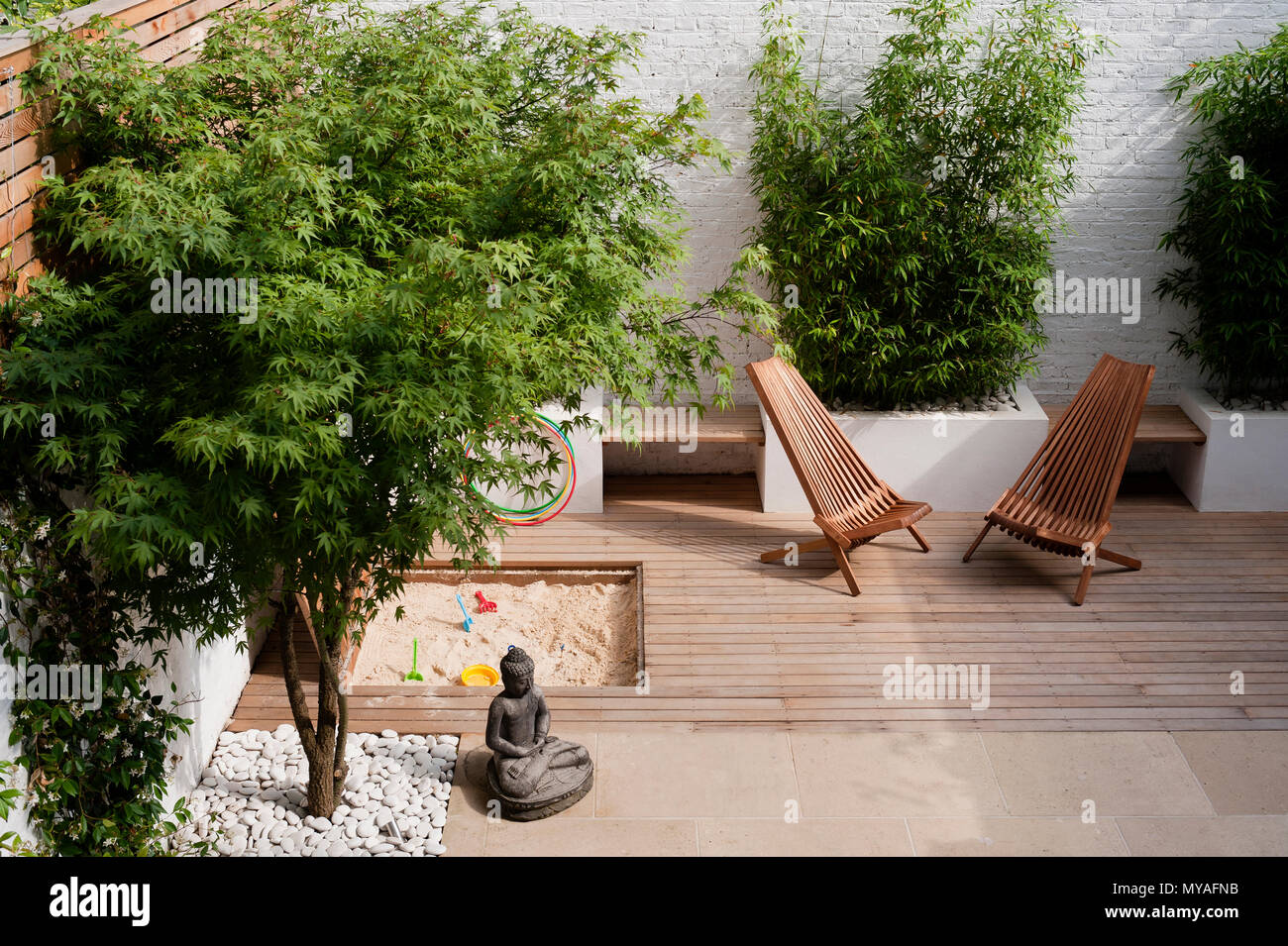 Arbres et bac à sable sur un patio en bois Banque D'Images