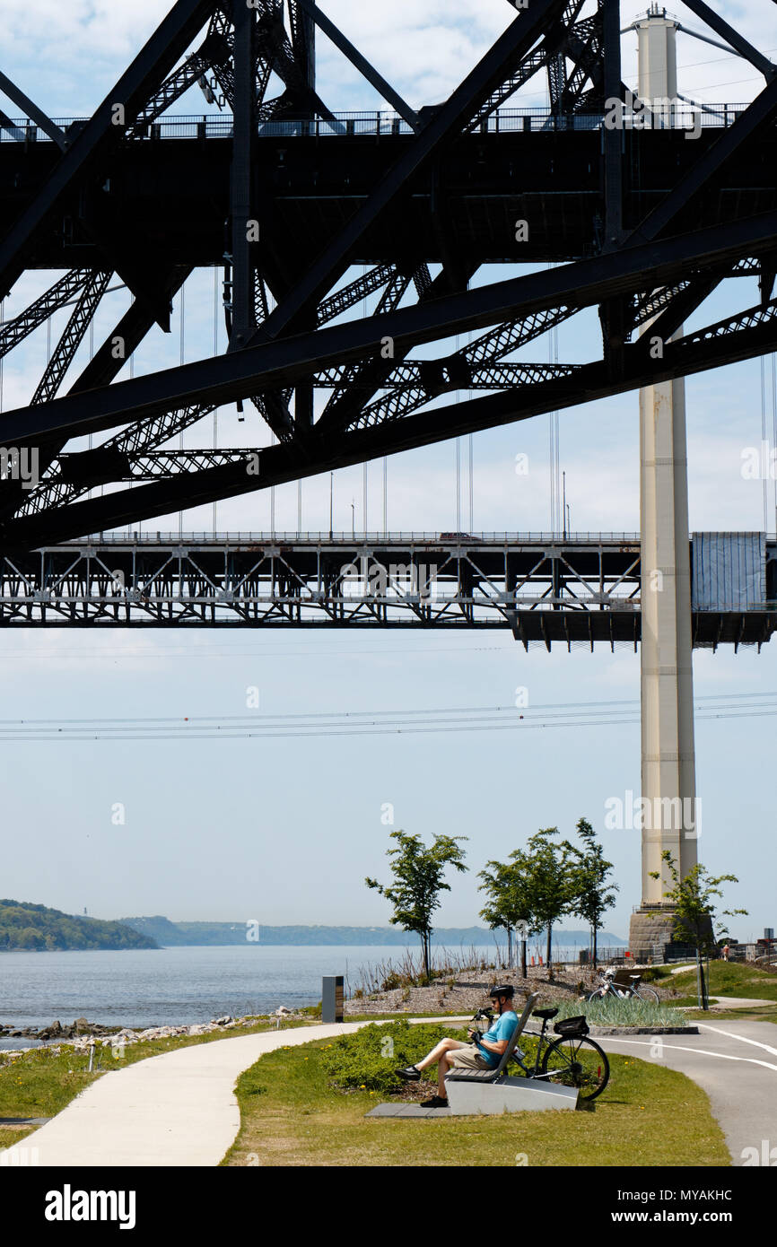 Un cycliste de détente sur la Promenade Samuel de Champlain cbike chemin dans la ville de Québec, Canada avec le Pont du Québec Frais généraux Banque D'Images