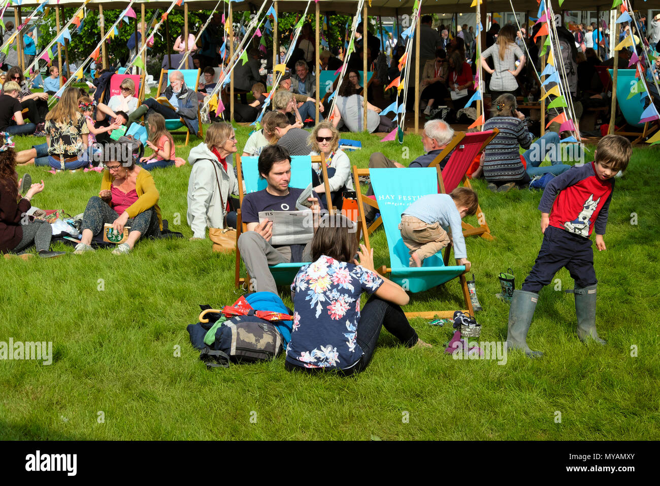 Les gens assis dans des chaises longues de détente la lecture de livres par les manifestations sur le site de Hay Festival de soleil 2018 Hay-on-Wye au Pays de Galles UK KATHY DEWITT Banque D'Images