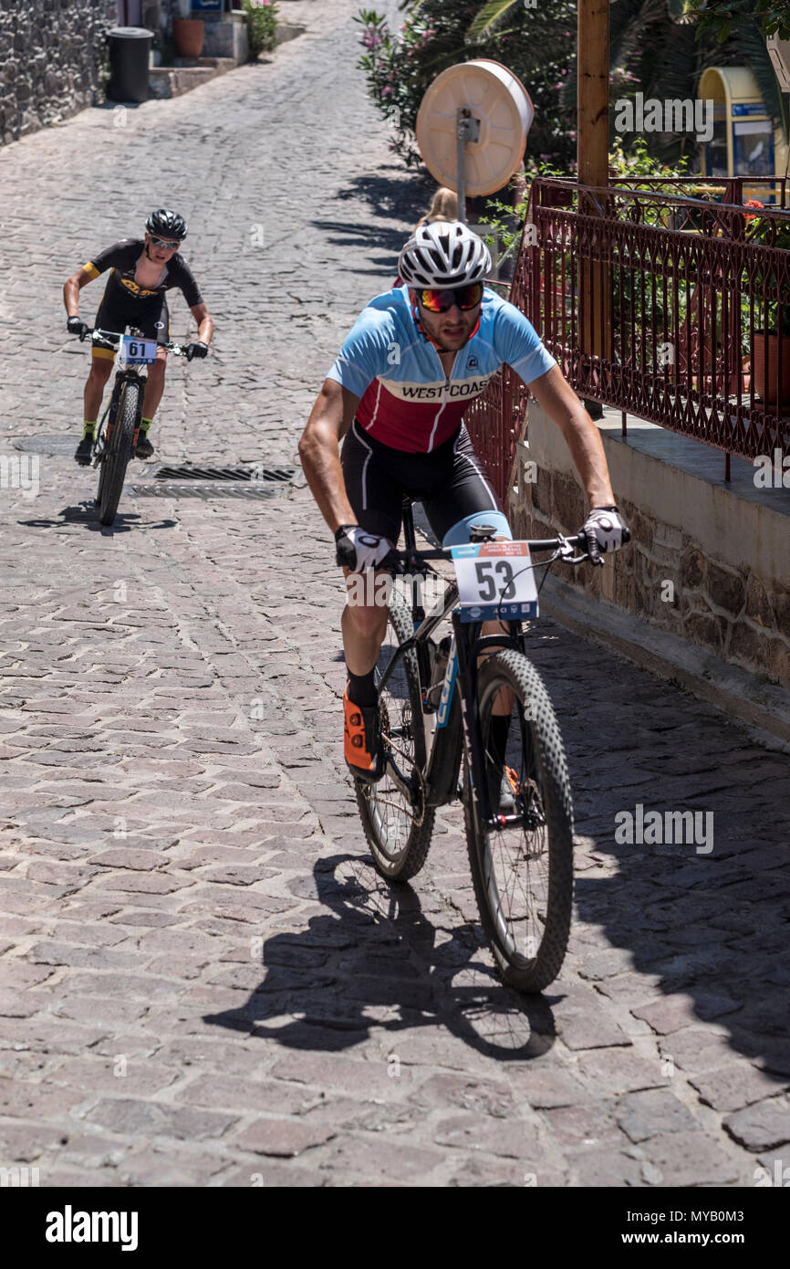 Les cyclistes masculins grecs rivaliser sur la scène internationale, une course de VTT dans les rues de du village grec de Molyvos sur l'île de Lesbos Banque D'Images