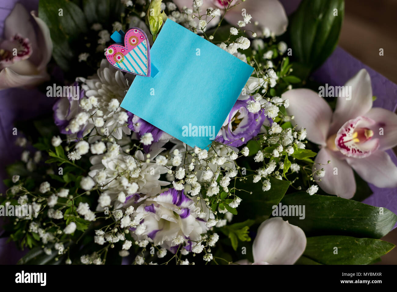 Carte bleu blanc avec fleurs orchidées ,style minimal.carte carton vide avec des fleurs.carte de souhaits avec bouquet de fleurs blanches .Carte postale avec des fleurs fraîches et balise vide pour votre texte. Banque D'Images