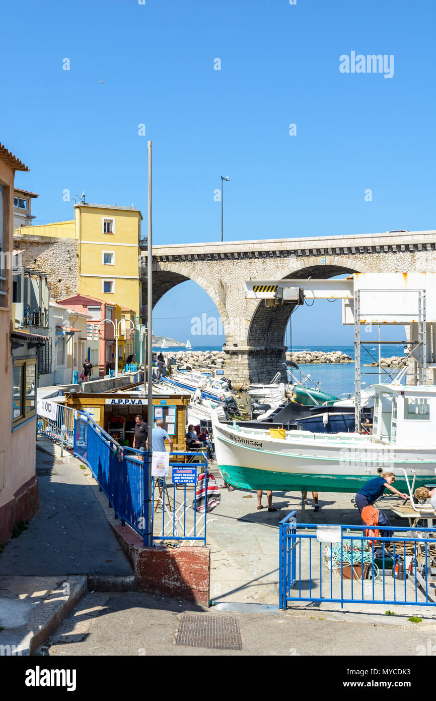 Le petit port de pêche du Vallon des Auffes à Marseille par un matin ensoleillé avec des bateaux et à l'arsenal et le pont-route de la Corniche Kennedy. Banque D'Images
