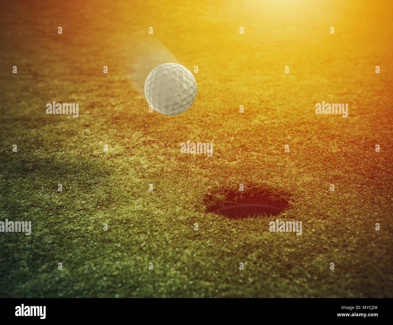Balle de golf près du trou dans un champ d'herbe Banque D'Images
