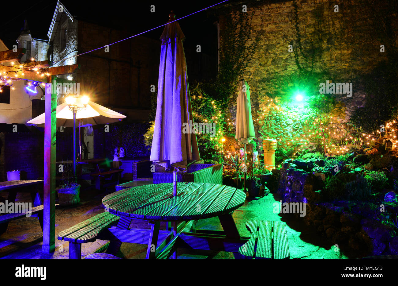 Le jardin illuminé au Village Inn, vieux village de Shanklin, sur l'île de Wight, ressemble enchanteresse la nuit après la pluie. Banque D'Images
