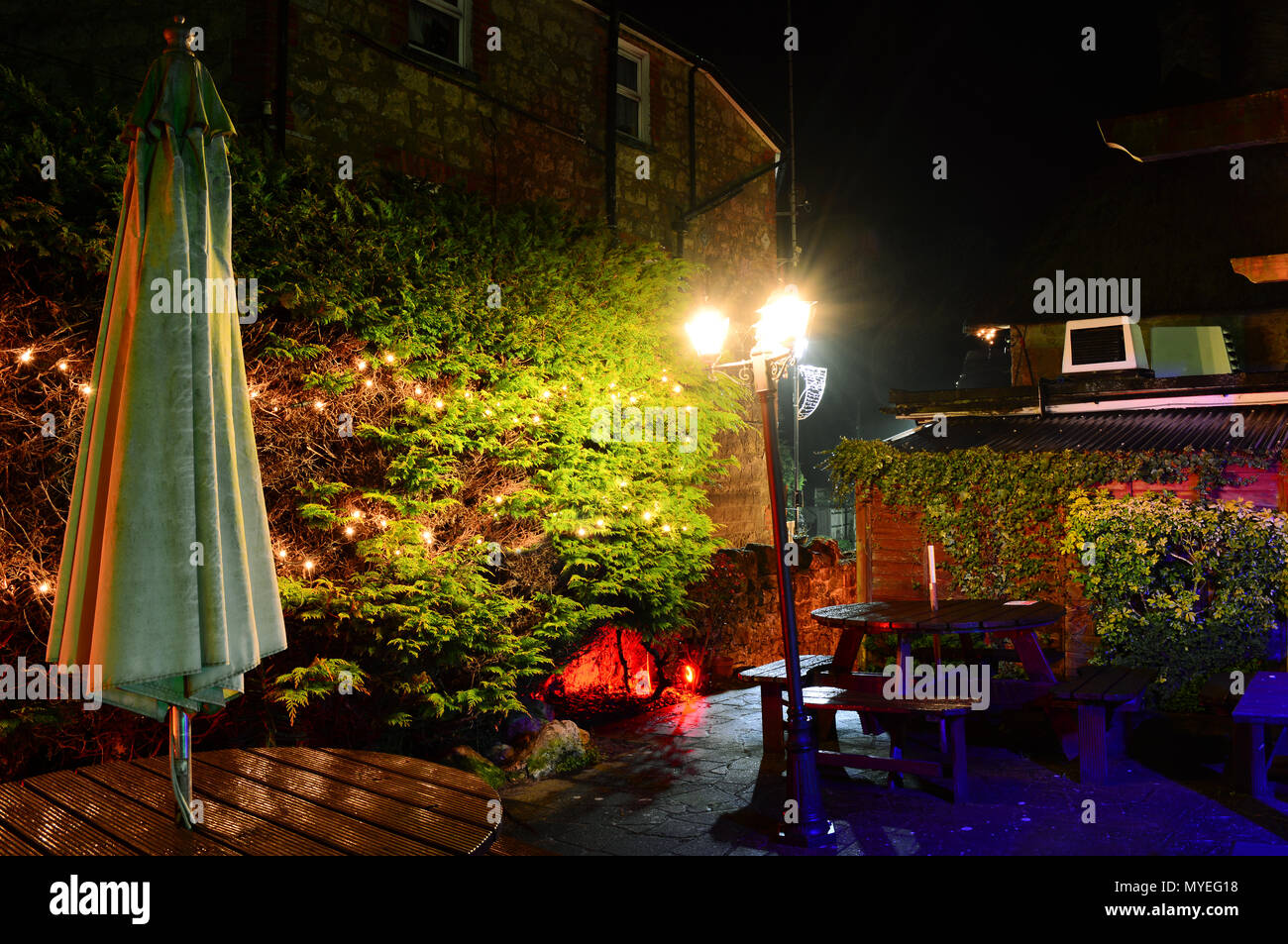 Le jardin illuminé au Village Inn, vieux village de Shanklin, sur l'île de Wight, ressemble enchanteresse la nuit après la pluie. Banque D'Images