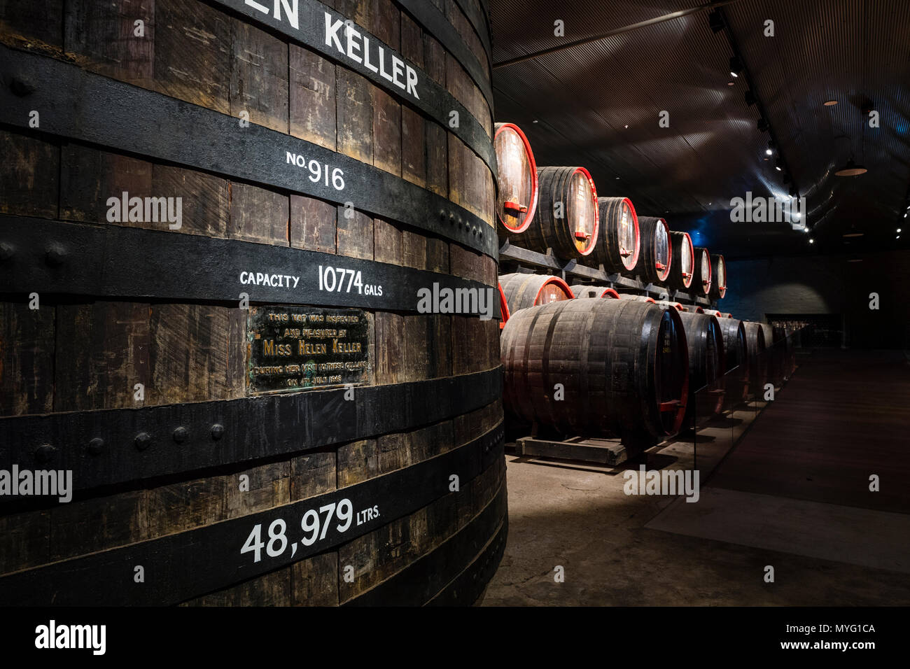 Une rangée de tonneaux de vin et fûts stockés dans un tunnel souterrain à ambiance contrôlée. Banque D'Images