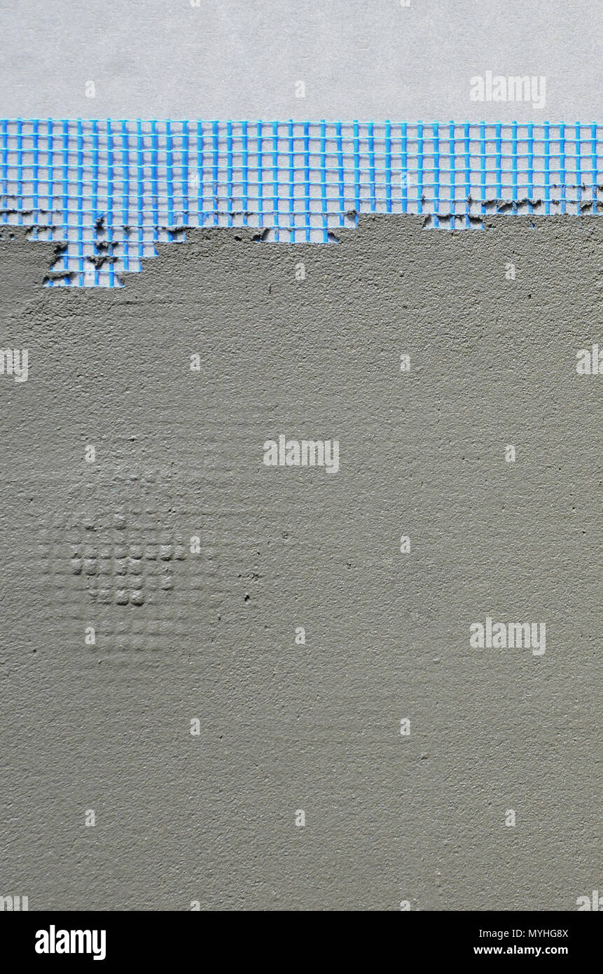 La texture du mur, recouvert de plaques de polystyrène mousse gris, recouvert d'un treillis d'armature bleu et recouvert d'un mélange de collage. Sta Banque D'Images