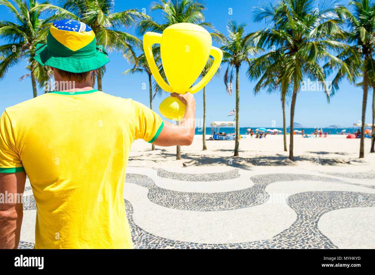 Fier drapeau brésilien à hat holding inflatable trophée à plage de Copacabana Rio de Janeiro Brésil Banque D'Images