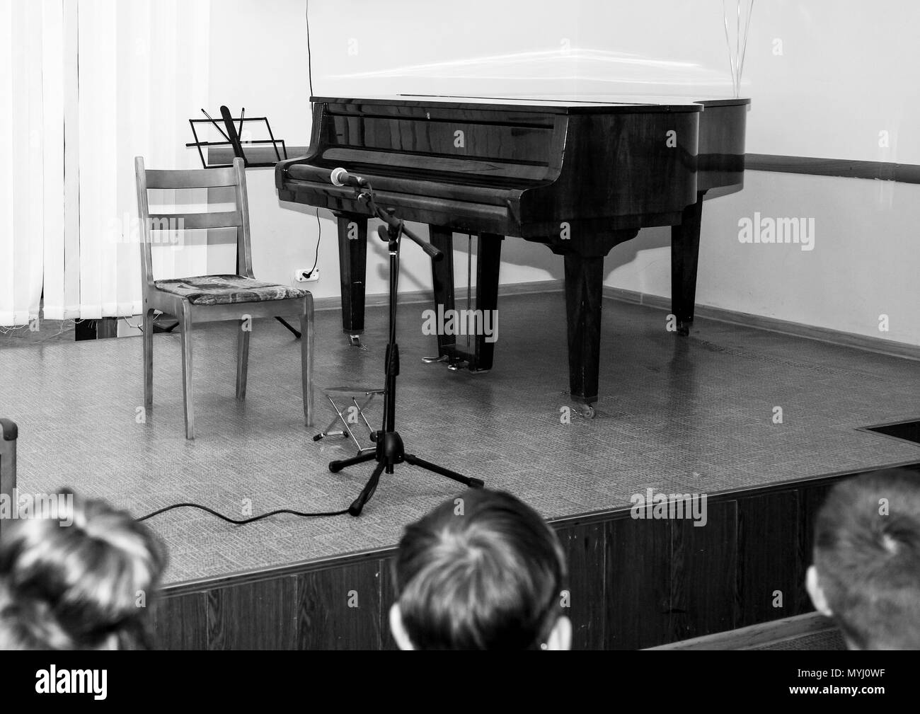 Photo en noir et blanc. Sur la scène est un piano et le public est en attente pour le concert. Banque D'Images