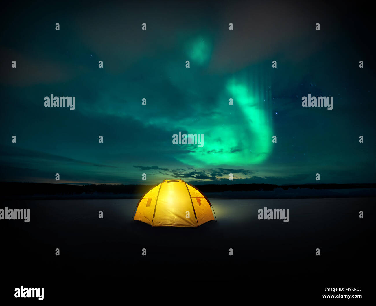 Dans le désert les lumières du Nord (aurores boréales) danse à travers le ciel de nuit en Suède, au-dessus de l'éclairage incandescent de la tente de camping. Pho Banque D'Images