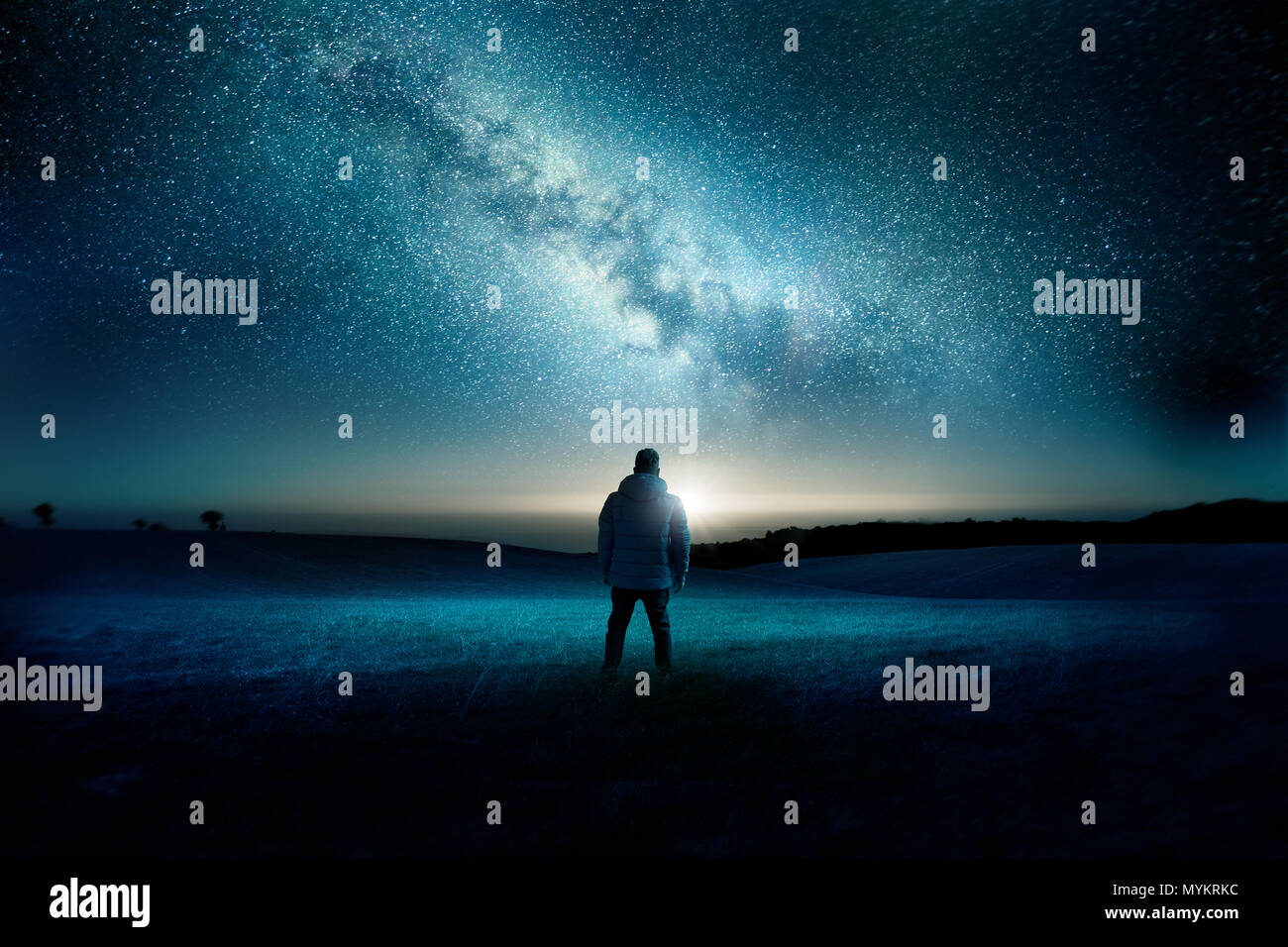 Un homme se regardant avec émerveillement et étonnement que la lune et voie lactée remplir le ciel de nuit. Paysage de nuit. Photo composite. Banque D'Images