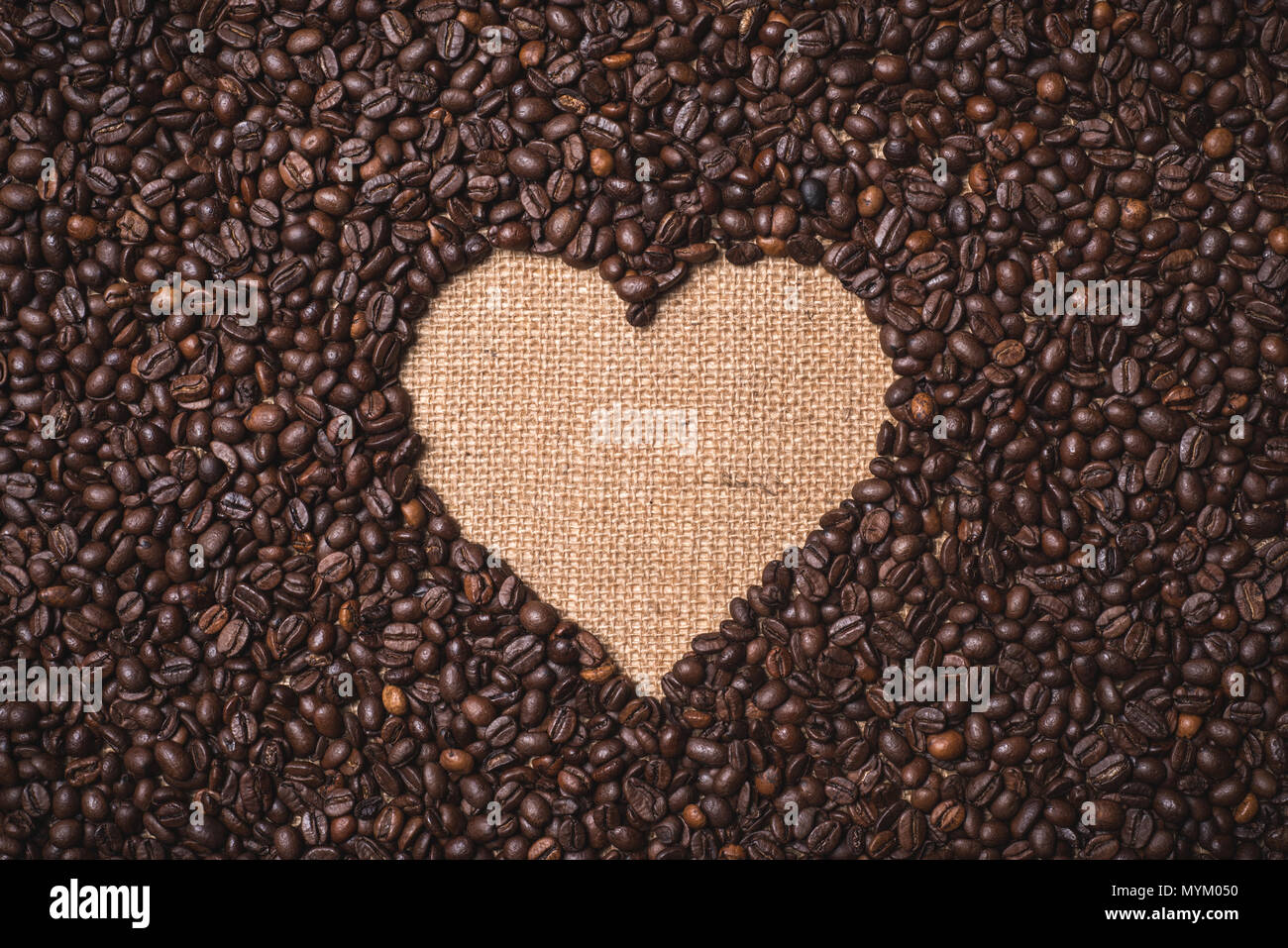 Vue de dessus les grains de café en forme de coeur sur textile juta Banque D'Images