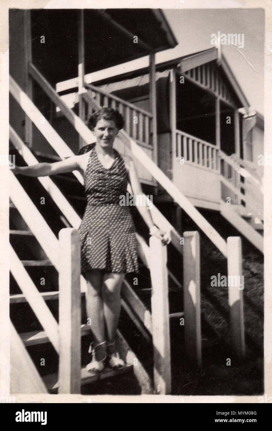 Femme portant un maillot de bain à la mode, pose sur les marches d'une cabane de plage Jutland-du-Nord, au Danemark. Photographie prise dans les années 1930 Banque D'Images