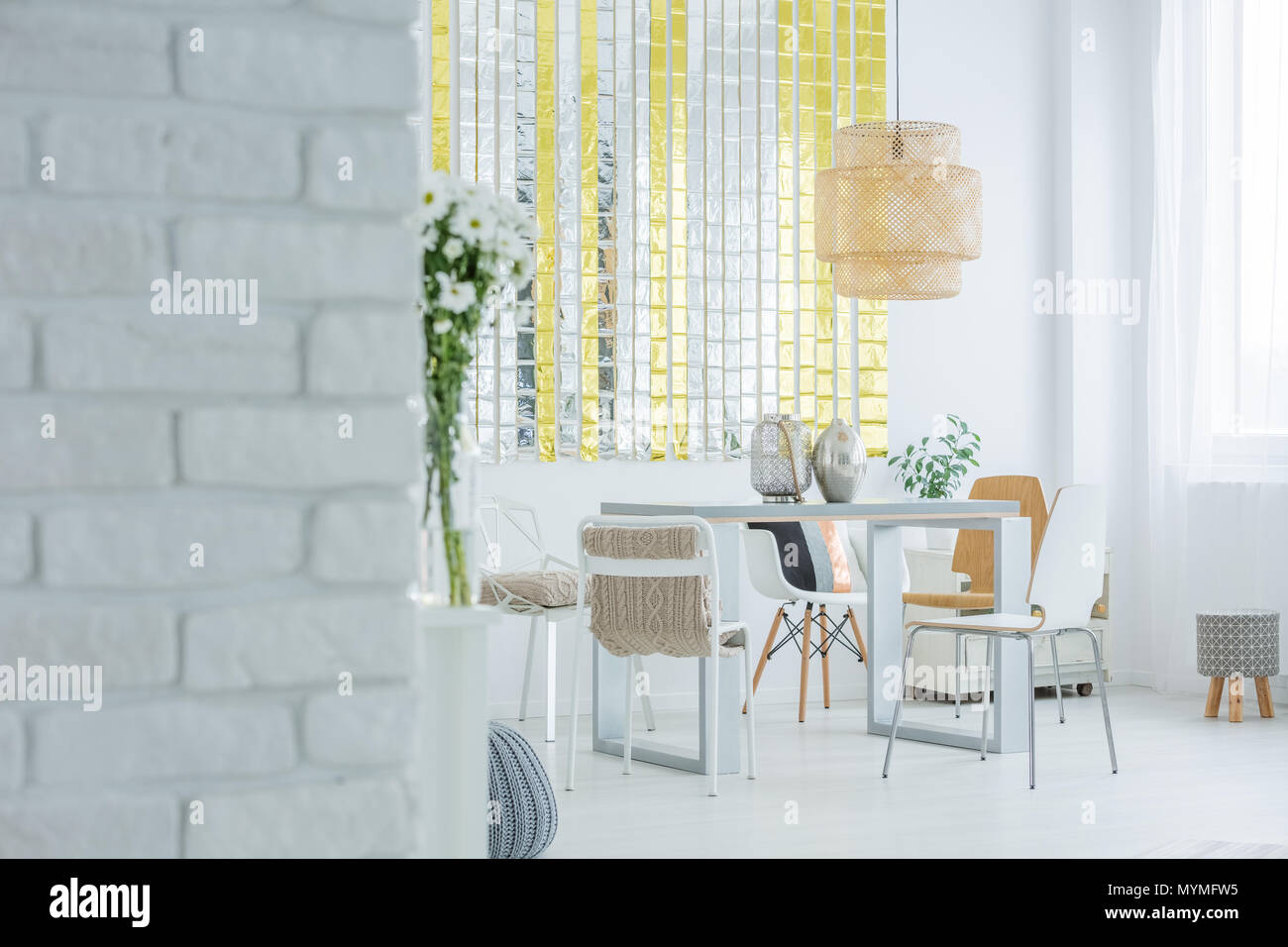 Appartement moderne avec mur en brique blanche, table à manger et chaises Banque D'Images