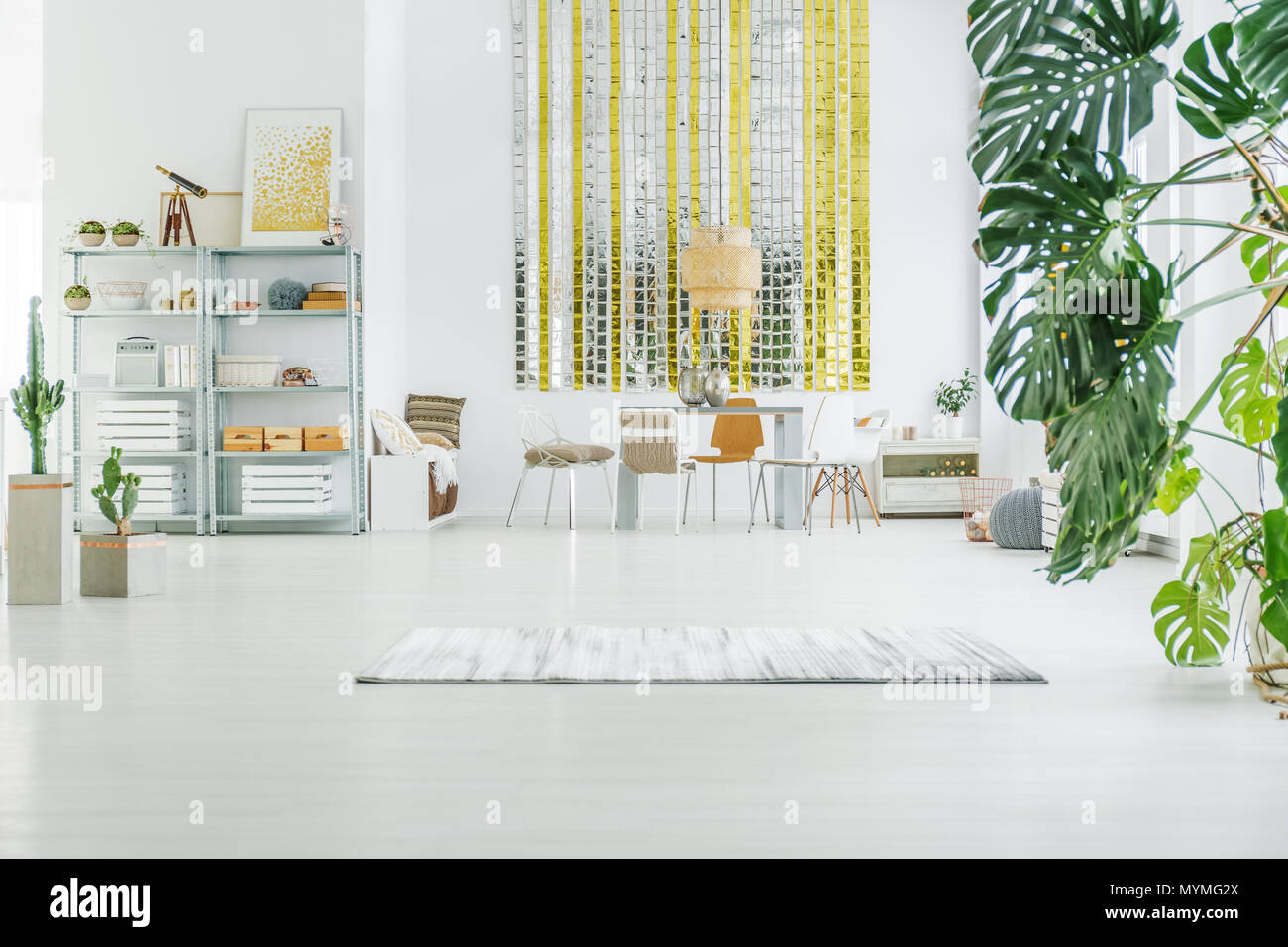 Appartement blanc avec classeur métallique, table, chaises et tapis Banque D'Images