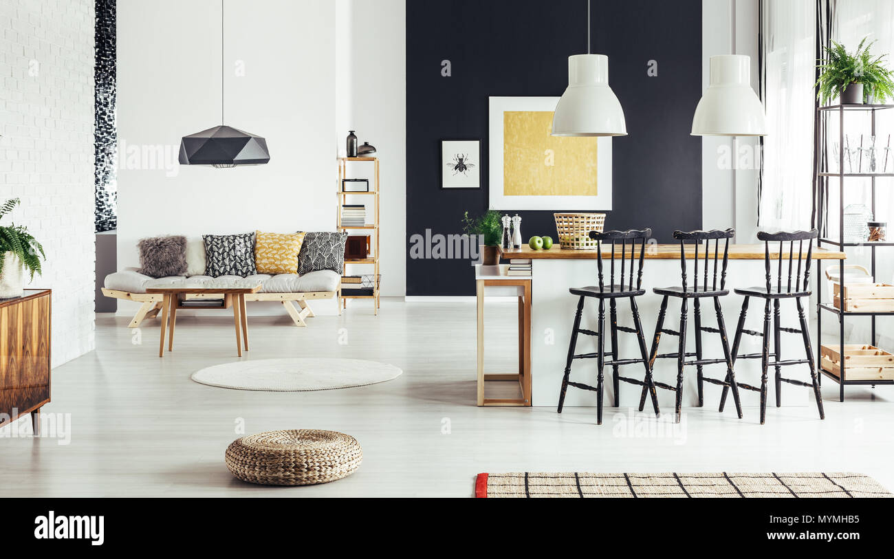 Oreillers beige à motifs sur un canapé dans la salle à manger rétro avec pouf et marbre et de tabourets de bar au comptoir Banque D'Images