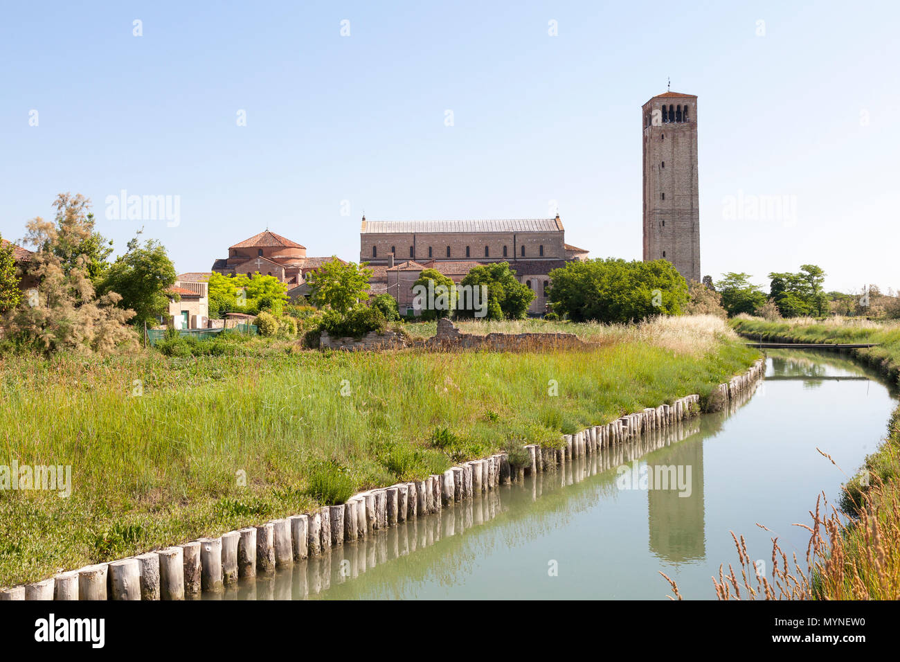 Basilica di Santa Maria Assunta et l'église de Santa Foaca au lever du soleil, l'île de Torcello, Venise, Vénétie, Italie avec le clocher reflétée dans le canal Banque D'Images