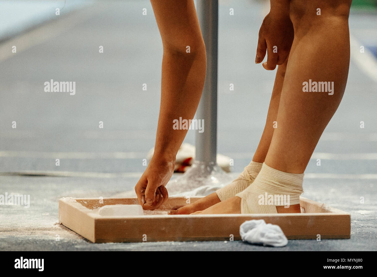 Gymnaste frotte la craie sur ses jambes en gymnastique Exercices sur poutre Banque D'Images