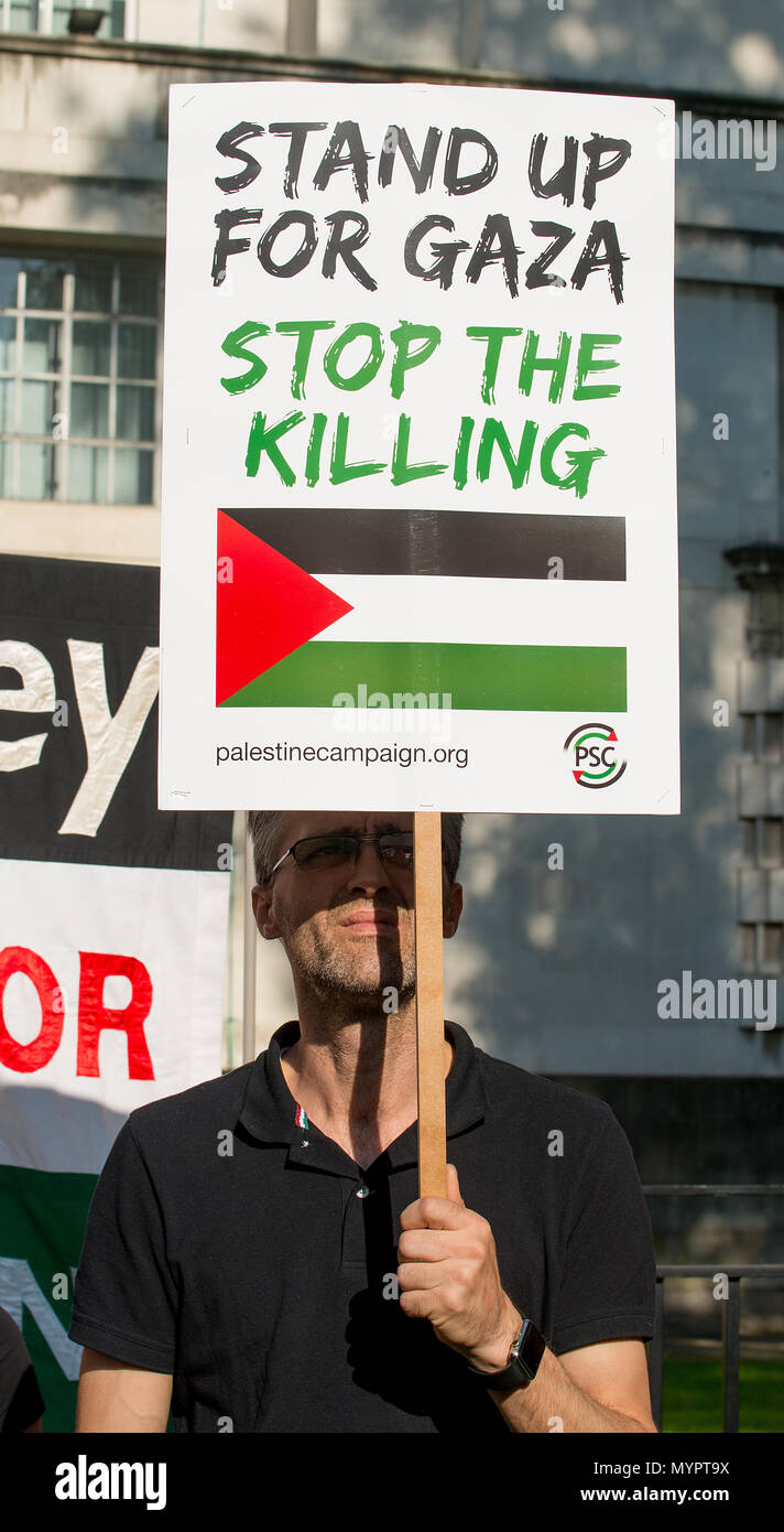 Manifestant avec affiche de la bande de Gaza : Arrêtez le massacre rassemblement à Whitehall, Londres, pour protester contre des civils palestiniens tués par l'armée israélienne. Banque D'Images