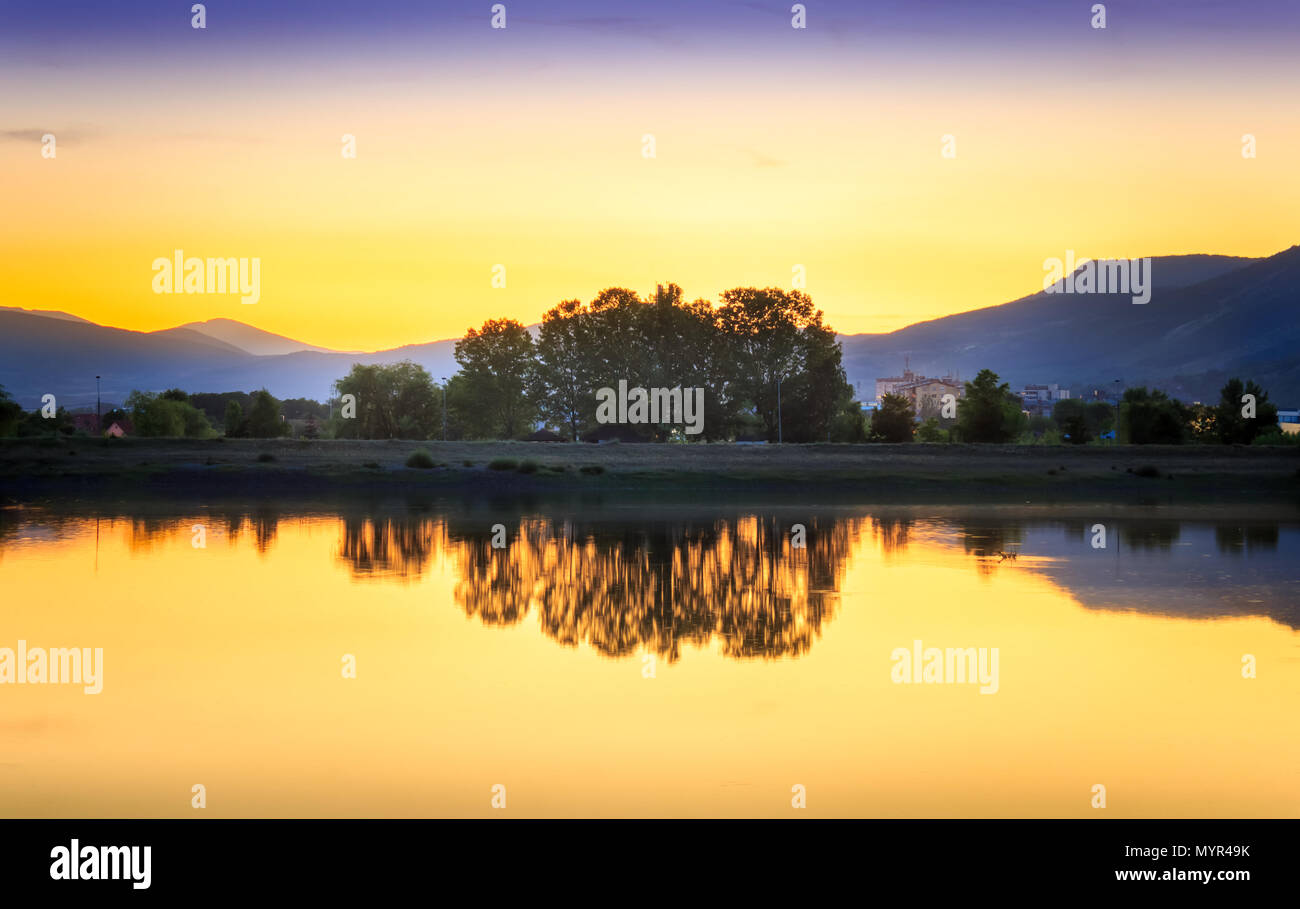 Heure d'or parfait coucher de soleil sur le lac calme, réfléchi avec gradient dans le ciel et soyeuse, de l'eau brillant Banque D'Images