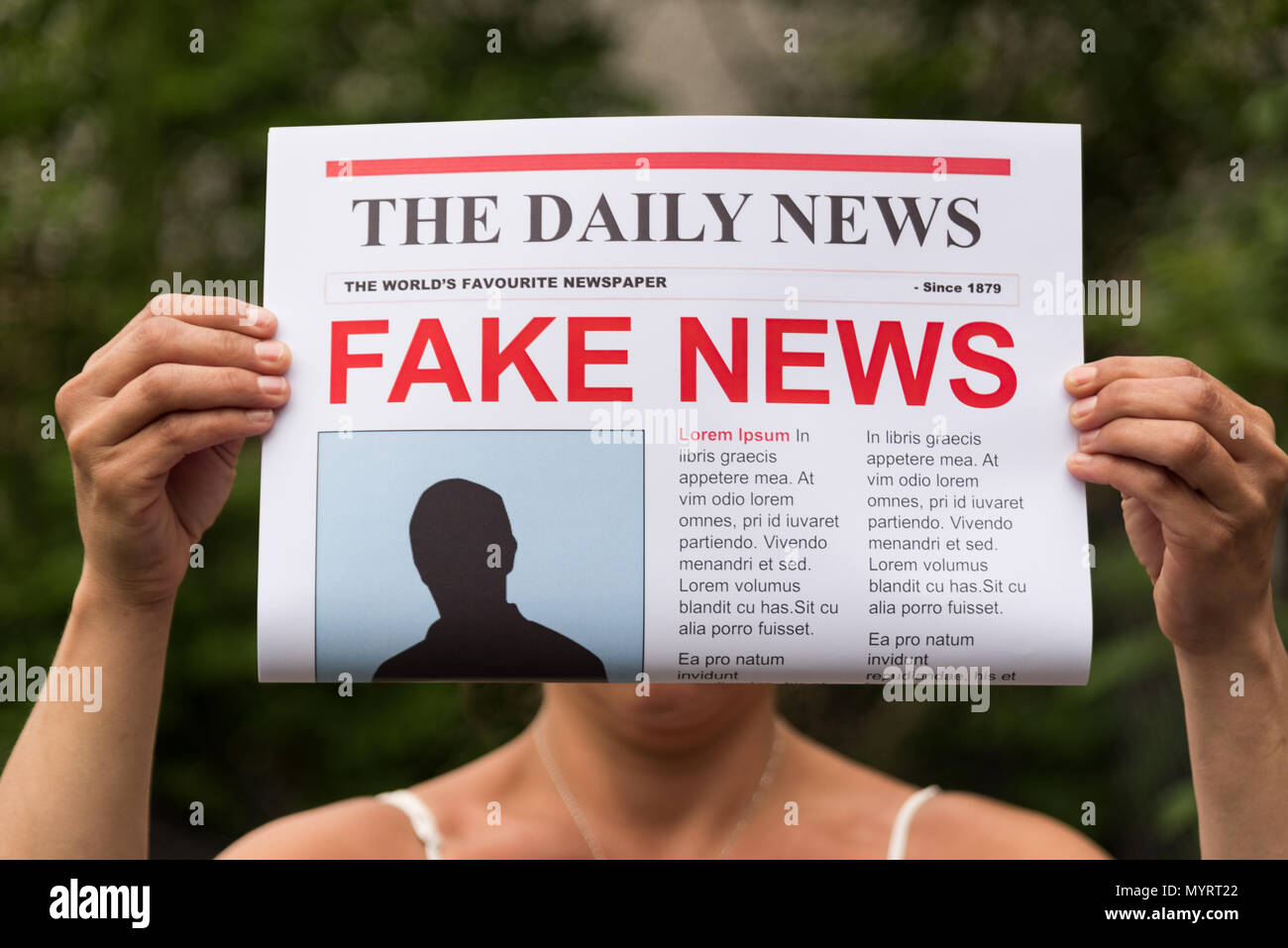Femme tenant un journal avec le titre fake news Banque D'Images