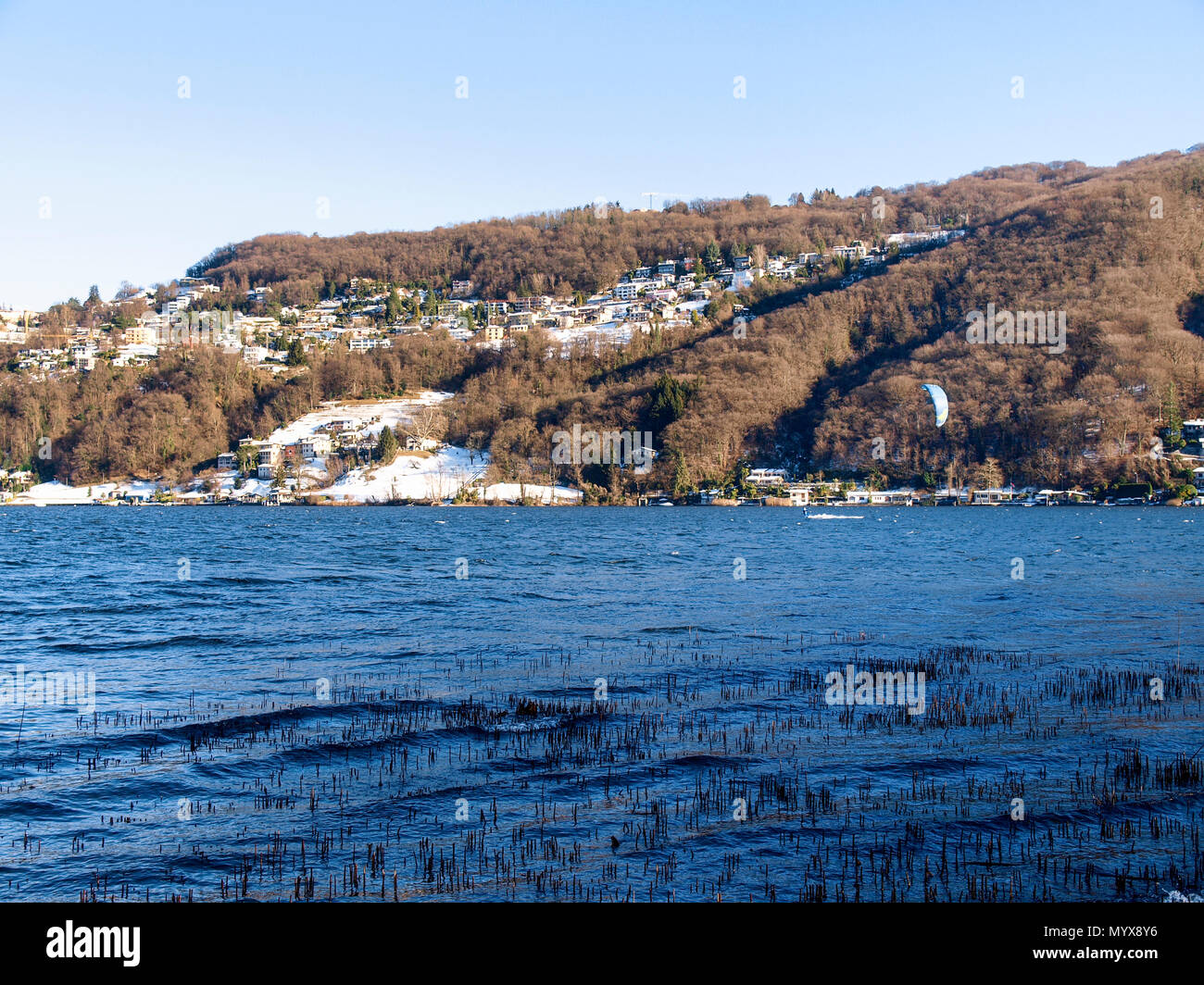 Agno, Suisse - 15 janvier 2017 : Kitesurfer sur le petit lac mirror pendant un jour d'hiver ensoleillé Banque D'Images