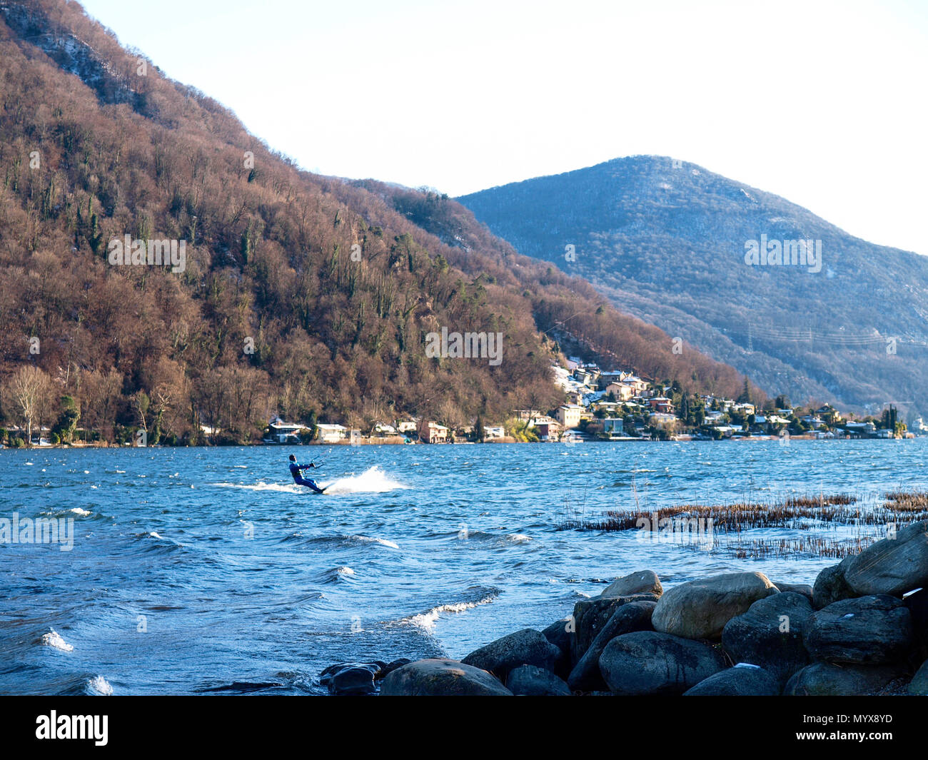 Agno, Suisse - 15 janvier 2017 : Kitesurfer sur le petit lac mirror pendant un jour d'hiver ensoleillé Banque D'Images