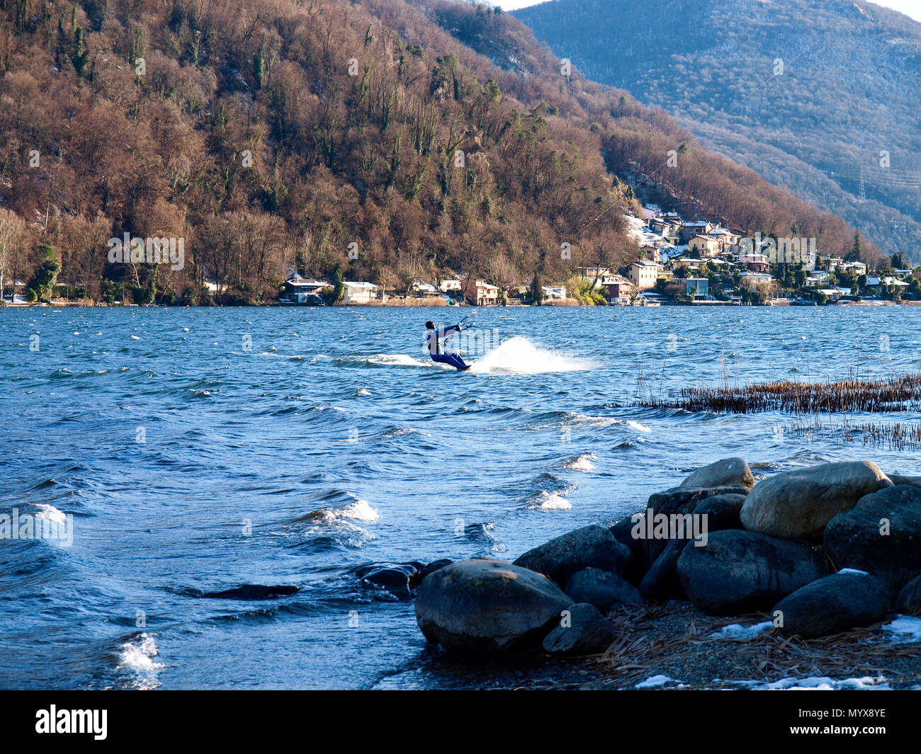 Agno, Suisse - 15 janvier 2017 : Kitesurfer sur le petit lac mirror pendant un jour d'hiver ensoleillé Banque D'Images