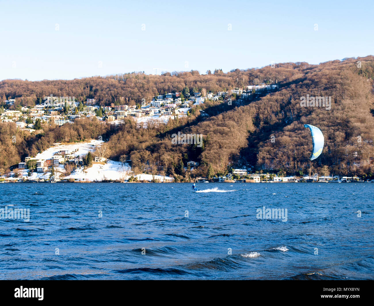 Agno, Suisse - 15 janvier 2017 : Kitesurfer sur le petit lac mirror pendant un jour d'hiver ensoleillé Banque D'Images