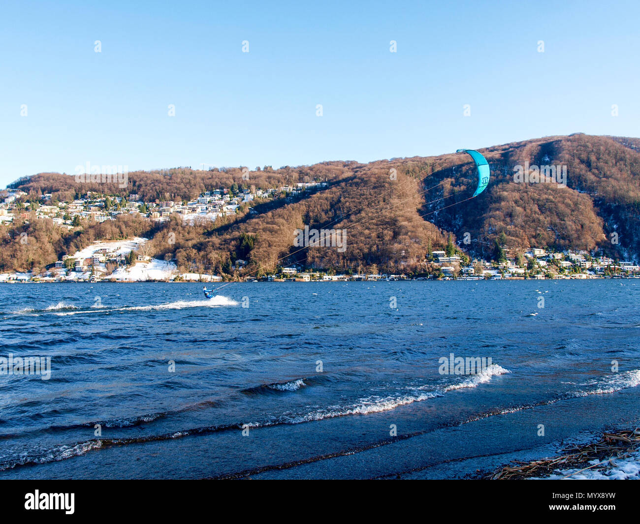 Agno, Suisse - 15 janvier 2017 : Kitesurfer sur le petit lac mirror pendant un jour d'hiver ensoleillé Banque D'Images