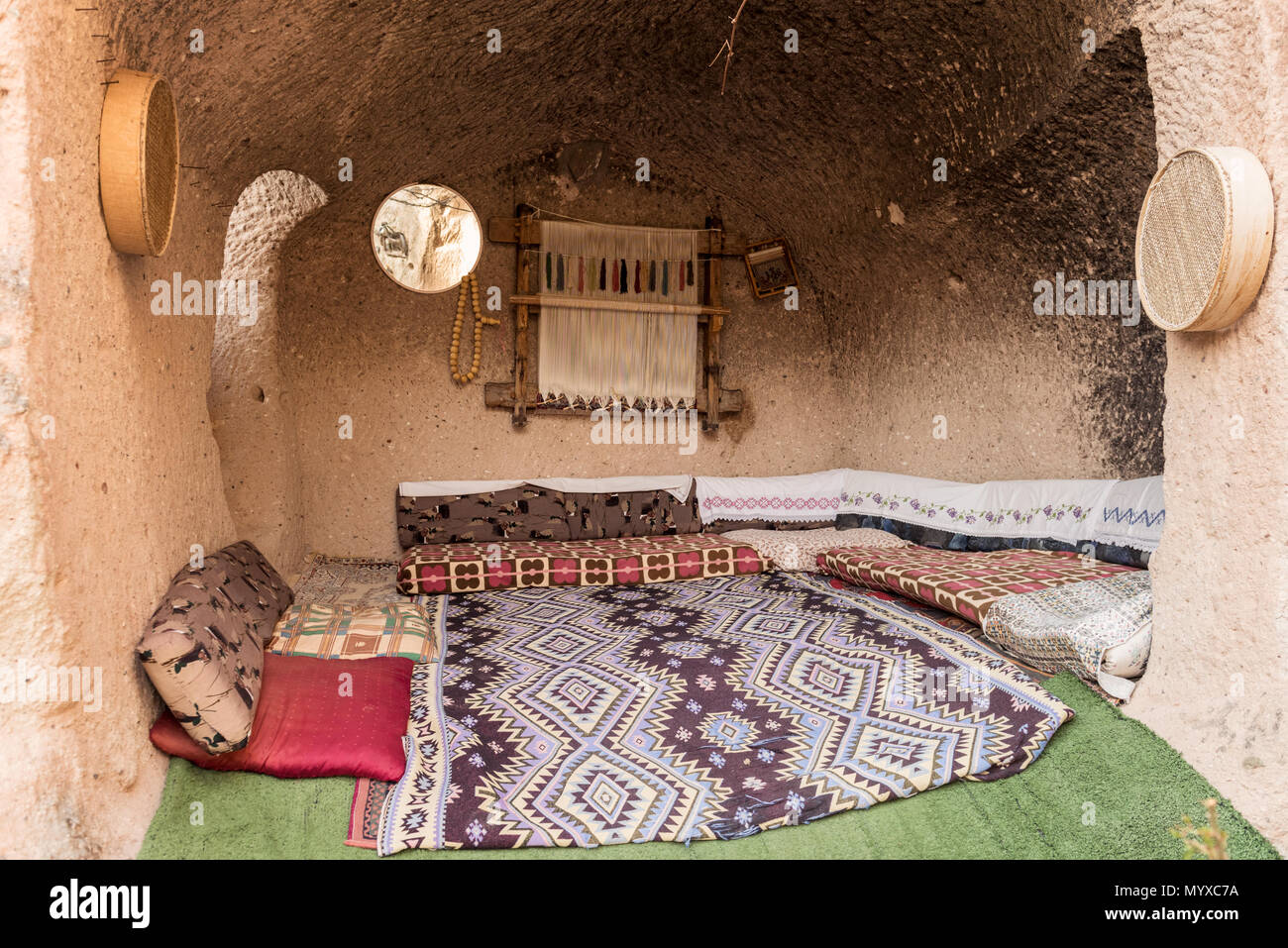 Parc national de Cappadoce. Un intérieur de salle de grotte confortable avec des sièges au sol traditionnels, des coussins à motifs colorés et des tapis. Banque D'Images