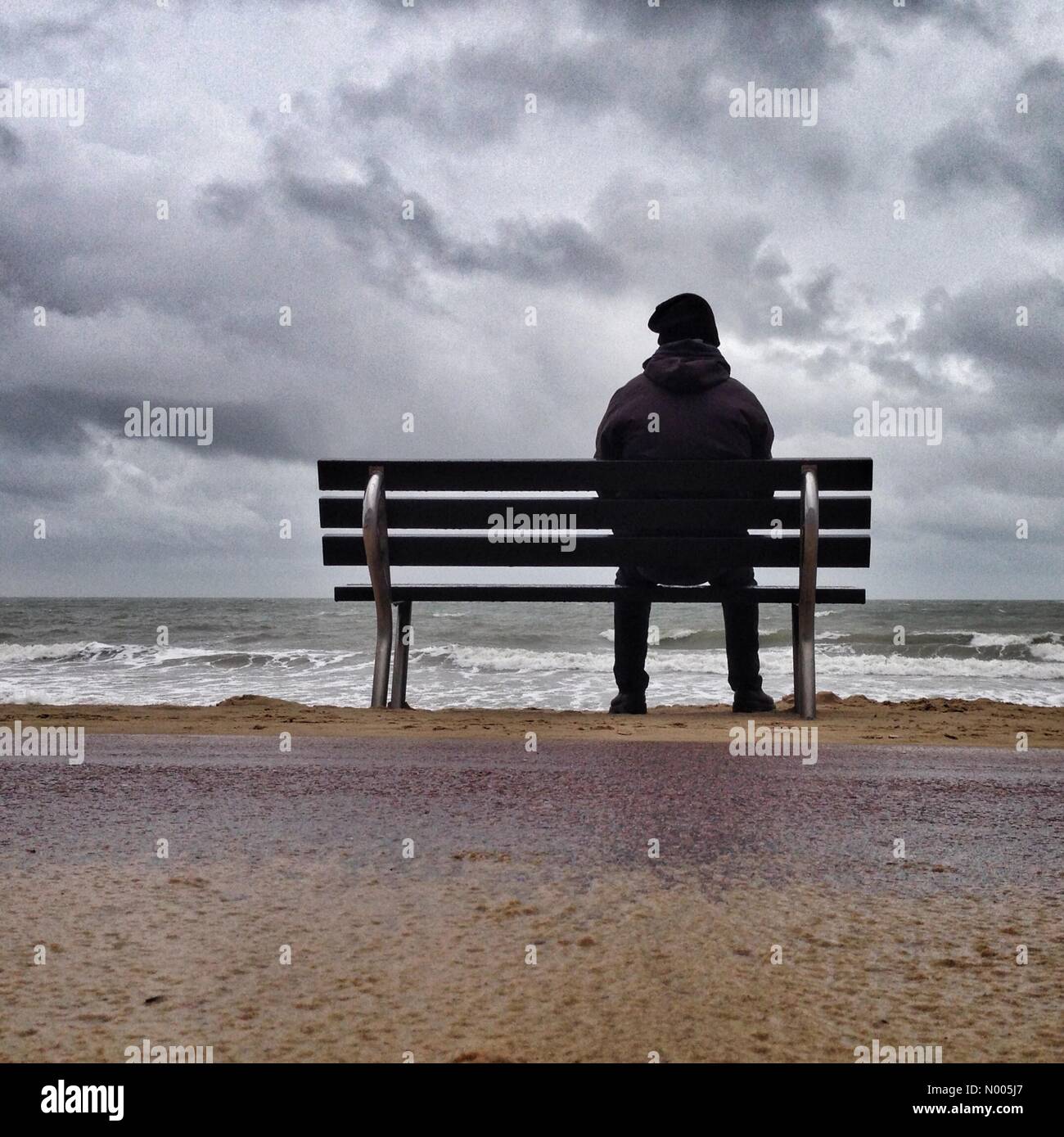 Personne assise sur un banc seul à la plage de Bournemouth Photo Stock -  Alamy