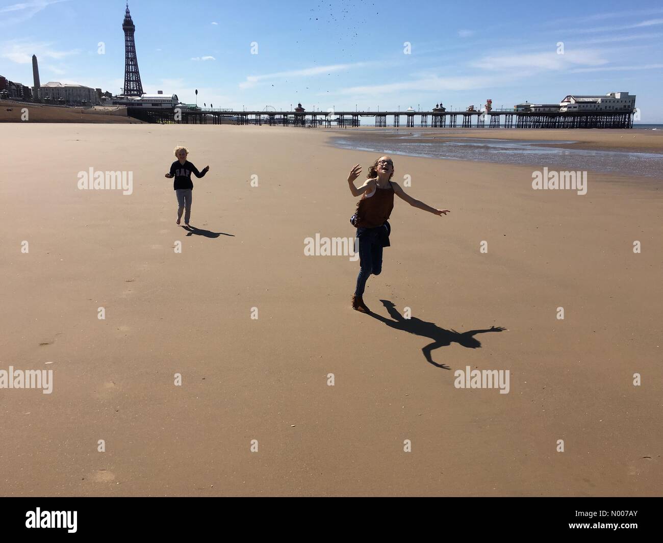 Météo France : journée ensoleillée à Blackpool. Deux jeunes filles s'amusant sur la plage en face de la Jetée Nord Banque D'Images Météo France : journée ensoleillée à Blackpool. Deux jeunes filles s'amusant sur la plage en face de la Jetée Nord Banque D'Images